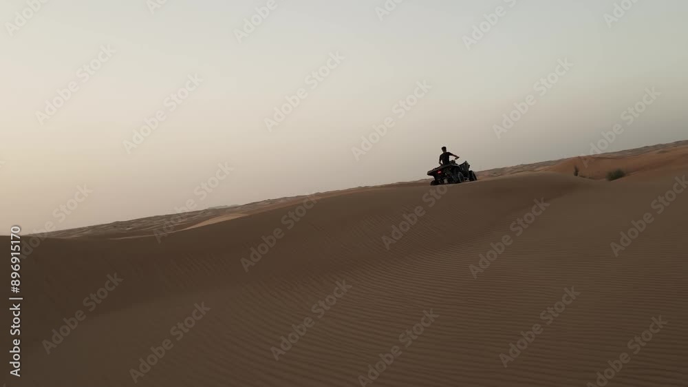 Experience the thrill of Dubai's desert like never before! Watch as a young man speeds through the stunning sand dunes of Dubai on a scorching sunny day, captured from an exhilarating FPV drone. Experience the thrill of Dubai's desert like never before! Watch as a young man speeds through the stunning sand dunes of Dubai on a scorching sunny day, captured from an exhilarating FPV drone.