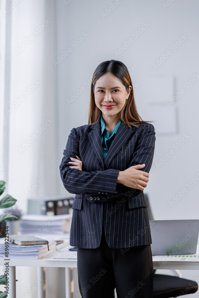 Beautiful Happy Asian businesswoman standing with her arms crossed and looking at the camera in the Workplace business people concept Beautiful Happy Asian businesswoman standing with her arms crossed and looking at the camera in the Workplace business people concept