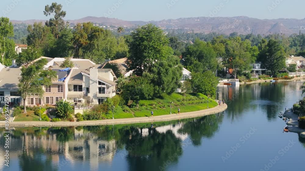 In the morning, runners enjoy jogging around a beautiful lake in Calabasas, California, USA, in a peaceful environment with lush green surroundings In the morning, runners enjoy jogging around a beautiful lake in Calabasas, California, USA, in a peaceful environment with lush green surroundings