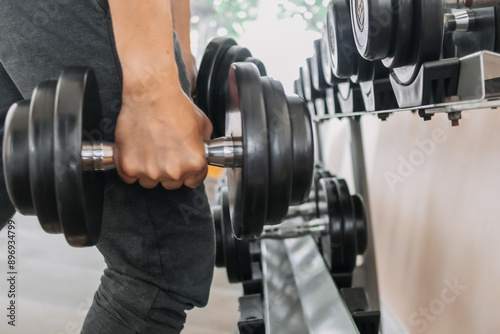 Close up of fitness hand catching and holding dumbbell at gym, weight training workout and building arms muscles, healthcare concept.