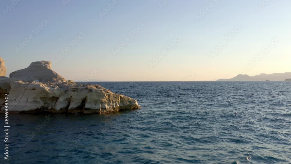 Aerial: flying backwards and low in Sarakiniko beach of Milos island, Cyclades, Greece during sunrise Aerial: flying backwards and low in Sarakiniko beach of Milos island, Cyclades, Greece during sunrise