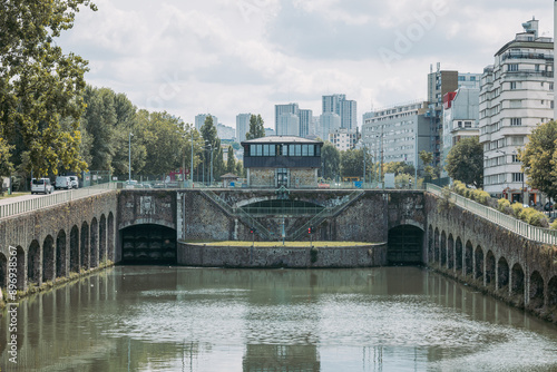 Obraz na płótnie Flanders bridge lock on the river in Paris, viewed from the norh. Visible high rise buildings in the rear. Famous river locks in Paris w salonie