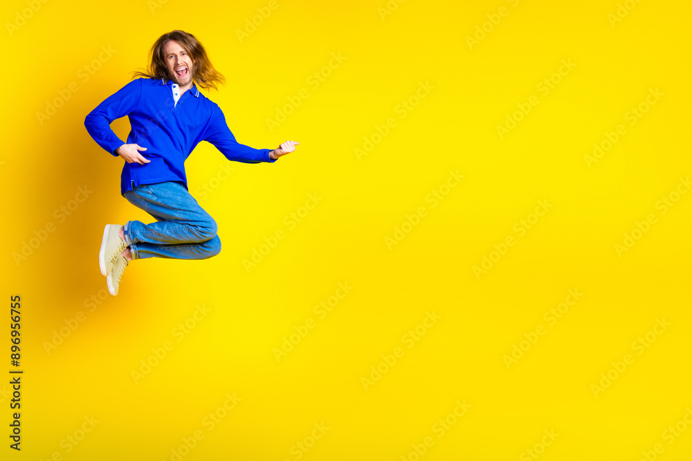 Photo of cheerful optimistic crazy man wear stylish blue clothes empty space isolated on yellow color background Photo of cheerful optimistic crazy man wear stylish blue clothes empty space isolated on yellow color background