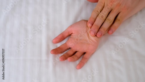 Man and woman holding hands lying in bed making love, hands close-up. Sex, intimate life, pleasure and love concept. Two lovers having a sex holding hands, sensual gesture.