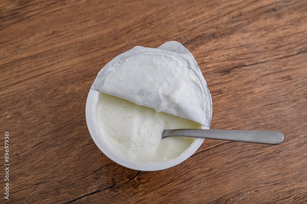 Fototapeta premium Plastikowy kubeczek z kwaśna śmietaną, widok z góry