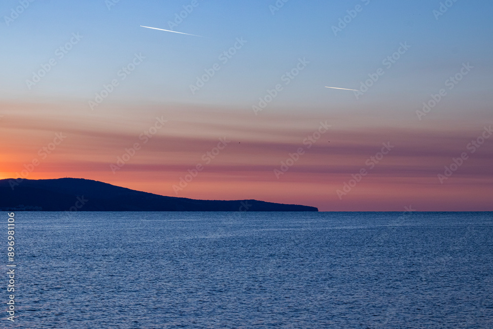 the sky over the sea before dawn, traces of airplanes in the sky the sky over the sea before dawn, traces of airplanes in the sky