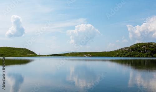 Two tourist silhouette walking on Augstee lake in Austria Alps mountain