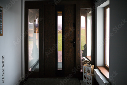 Main entrance/exit of a villa in a modern style. Front entrance to the house. Design of wooden doors with glass inserts in a hotel.