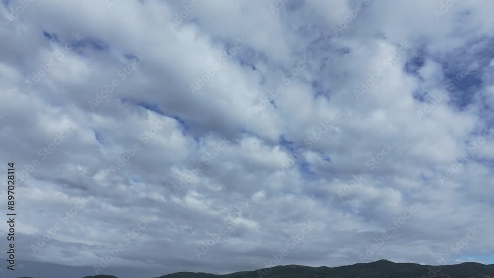 flight with a drone visualizing a row of mountains in the background of the filming and as the main shot a sky completely covered in clouds, there are blue brushstrokes of the sky between clouds flight with a drone visualizing a row of mountains in the background of the filming and as the main shot a sky completely covered in clouds, there are blue brushstrokes of the sky between clouds