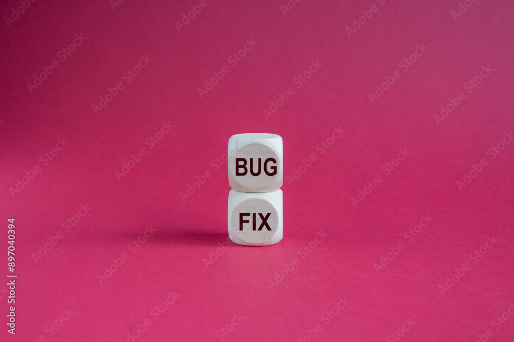 Bug fix message written on wooden cubes with pink background. Conceptual bug fix symbol. Bug fix message written on wooden cubes with pink background. Conceptual bug fix symbol.