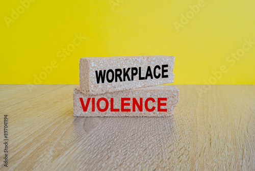 Obraz na płótnie WORKPLACE VIOLENCE symbol. Concept words WORKPLACE VIOLENCE on brick blocks. Beautiful yellow background, wooden table. Business concept. w salonie