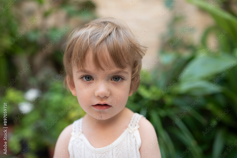 little blond boy with blue eyes in Andalusian patio looking at camera on a spring day little blond boy with blue eyes in Andalusian patio looking at camera on a spring day