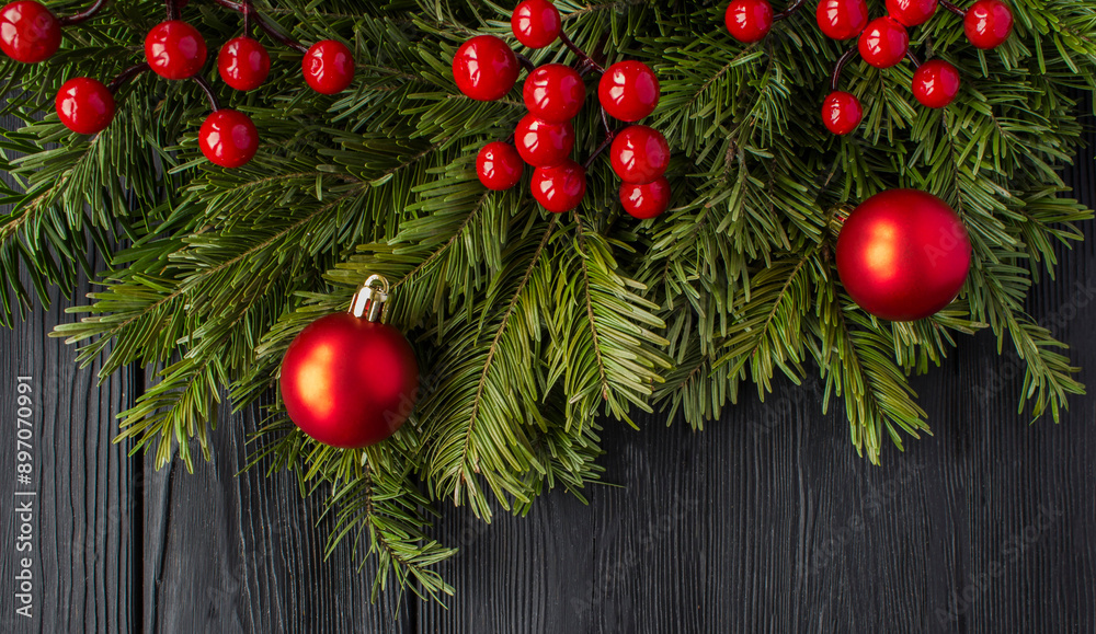 Christmas tree with red bead on the black wooden background. Top view. Close-up.