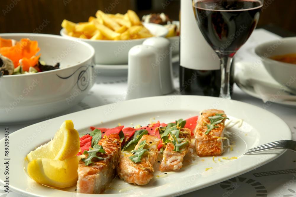 Grilled Salmon fillet with marinated vegetables served on the restaurant table Grilled Salmon fillet with marinated vegetables served on the restaurant table