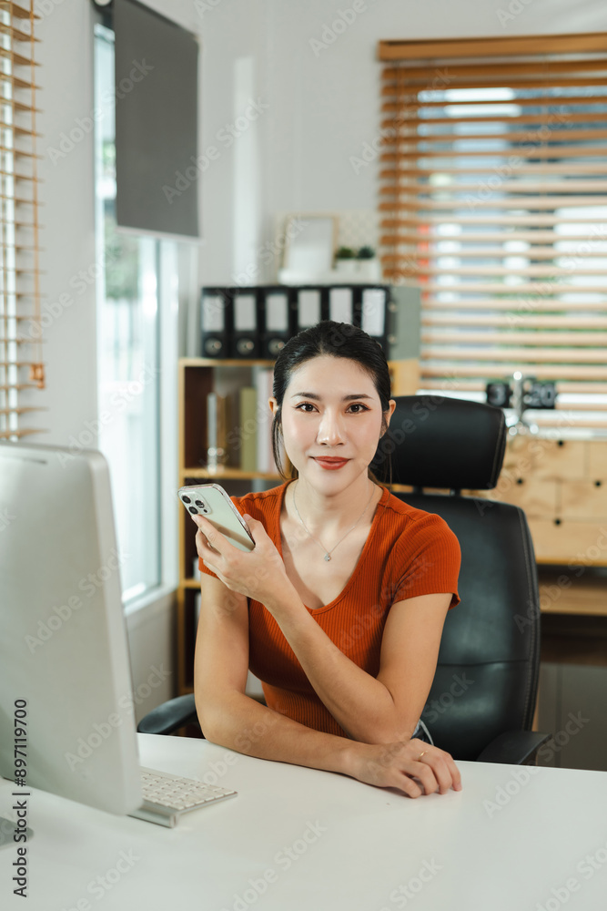 Female asian sitting at the desk, looking to camera. Female asian sitting at the desk, looking to camera.