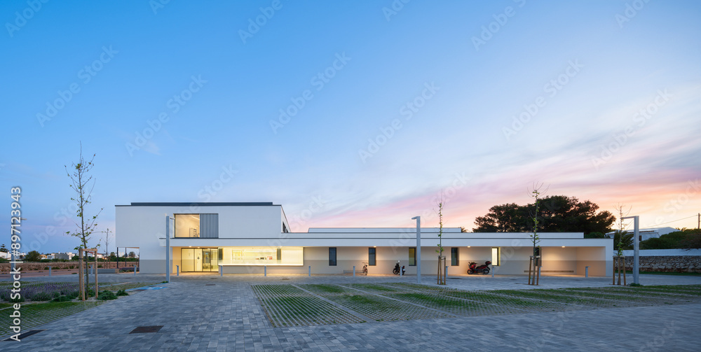 Modern hospital facade at sunset with clear skies Modern hospital facade at sunset with clear skies