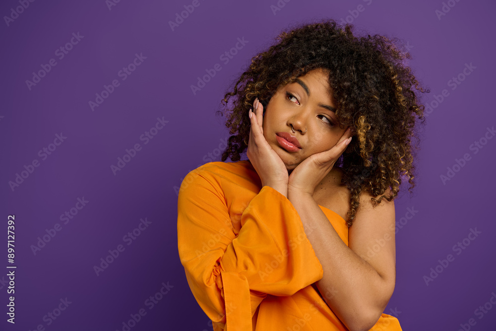 A beautiful African American woman with curly hair poses stylishly against a vibrant backdrop.