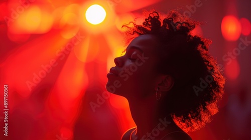 A serene moment of contemplation captured as a young person enjoys a peaceful moment amidst the vibrant red ambiance of a dreamy, demure setting