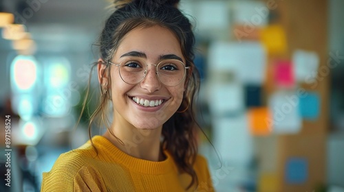 Free Download Confident and Creative: A young woman with a bright smile and a warm expression, wearing stylish round glasses and a yellow shirt - GFXLoad