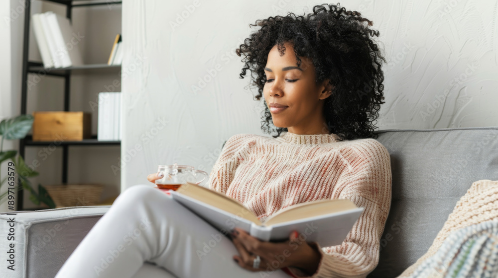 Serene African American Woman Enjoying Book and Tea at Home Serene African American Woman Enjoying Book and Tea at Home
