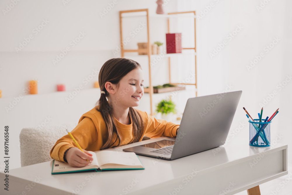 Portrait of smart schoolkid study laptop desk write notepad white interior apartment indoors Portrait of smart schoolkid study laptop desk write notepad white interior apartment indoors