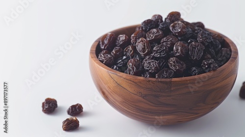 Raisins, cashews, or dried apricots in a natural wooden bowl on a plain background for healthy snacking. photo