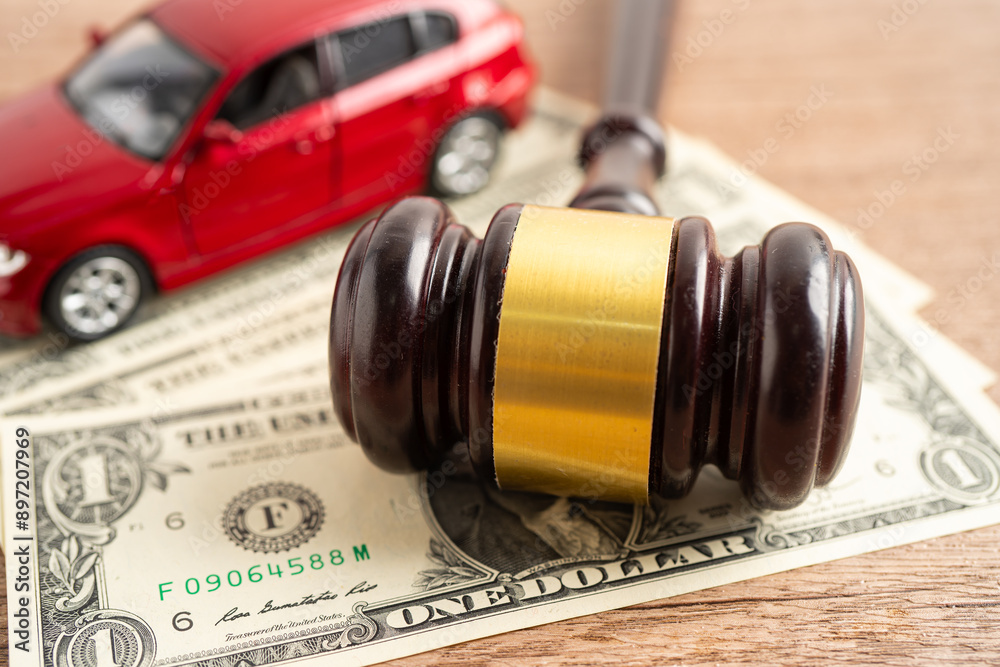 Hammer gavel judge and US dollar banknote money with car vehicle accident, insurance coverage claim lawsuit court case.