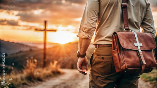 Missionary man with suitcase on his back walking through the field at sunset taking the Word of God