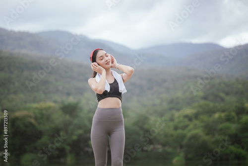 A beautiful woman jogs alone in the city, drinking water. Embracing an active lifestyle, she runs with energy and joy, showcasing fitness, health, and endurance, enjoying the outdoors and nature's bea photo