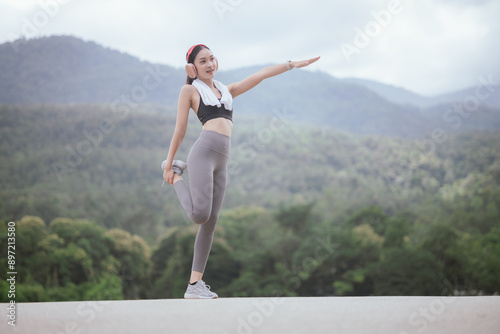 A beautiful woman jogs alone in the city, drinking water. Embracing an active lifestyle, she runs with energy and joy, showcasing fitness, health, and endurance, enjoying the outdoors and nature's bea © Witoon