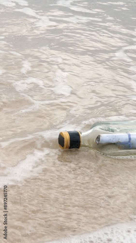 Messages in bottles have been used to send distress messages. Request for help in water on beach by sea or ocean with sand Messages in bottles have been used to send distress messages. Request for help in water on beach by sea or ocean with sand