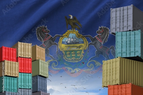 Pennsylvania US state flag and big stack of shipping cargo containers in docks with sky background close up photo