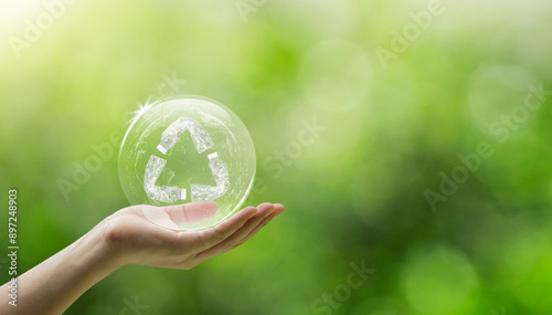 Fototapeta Naklejka Na Ścianę i Meble -  Hand holding earth with a recycling symbol is made of used plastic bottles. ecological waste management and a sustainable and economical lifestyle. promoting recycling and environmental sustainability