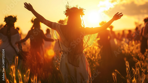 Women dancing in a field at sunset during Lammas festival. 