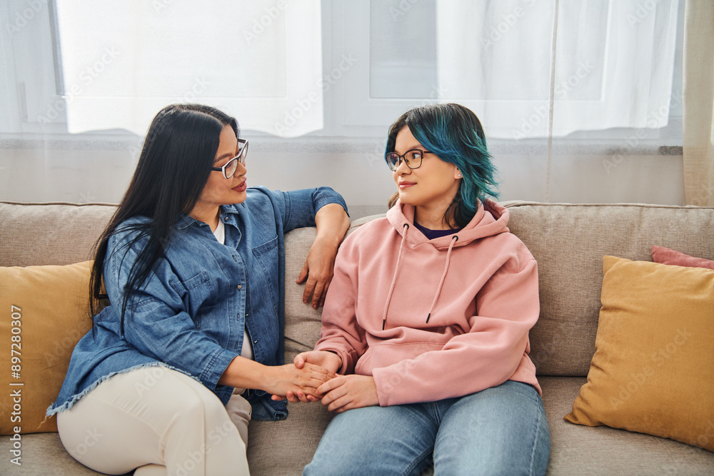 © LIGHTFIELD STUDIOS - An Asian mother and her teenage daughter in casual wear engage in a deep conversation while sitting on a cozy couch. © LIGHTFIELD STUDIOS - An Asian mother and her teenage daughter in casual wear engage in a deep conversation while sitting on a cozy couch.