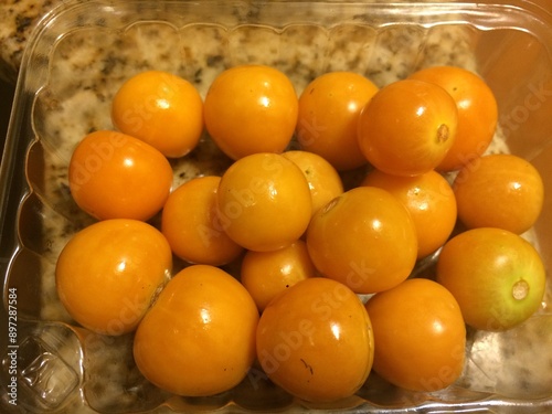 Fresh Pichuberries in a Plastic Container on the Counter photo