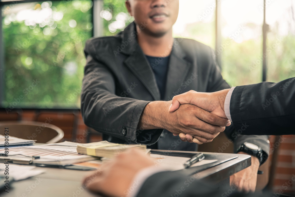 Business handshake and business people with money . Businessman shaking hands agreement confirmed in the investment business. Business handshake and business people with money . Businessman shaking hands agreement confirmed in the investment business.