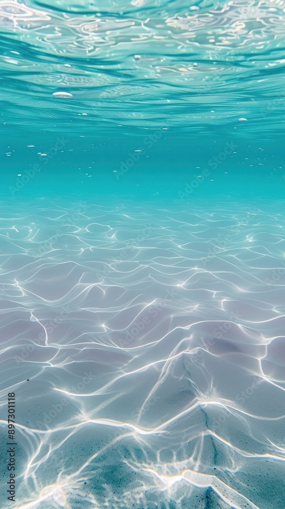 Fototapeta premium Turquoise water with sunlit sandy ocean floor patterns