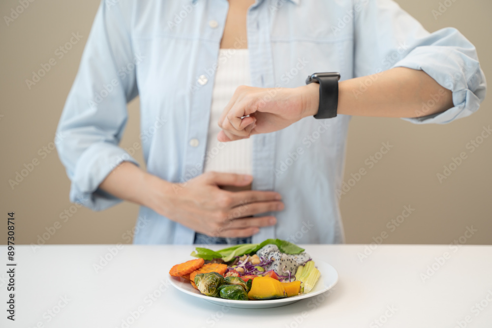 Intermittent fasting concept, Close-up on clock and people feeling hungry waiting time to eat during intermittent fasting diet session Intermittent fasting concept, Close-up on clock and people feeling hungry waiting time to eat during intermittent fasting diet session