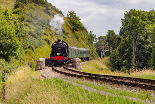 Discover a captivating steam engine chugging along a scenic railway track, showcasing the nostalgia and timeless elegance of classic train travel. Perfect for historical and transportation.