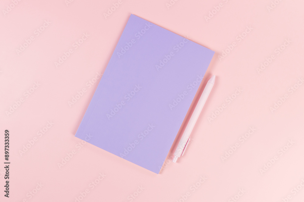Top view of purple notebook, pink pen on pink background. School, office wallpaper. Flat lay, copy space. Top view of purple notebook, pink pen on pink background. School, office wallpaper. Flat lay, copy space.