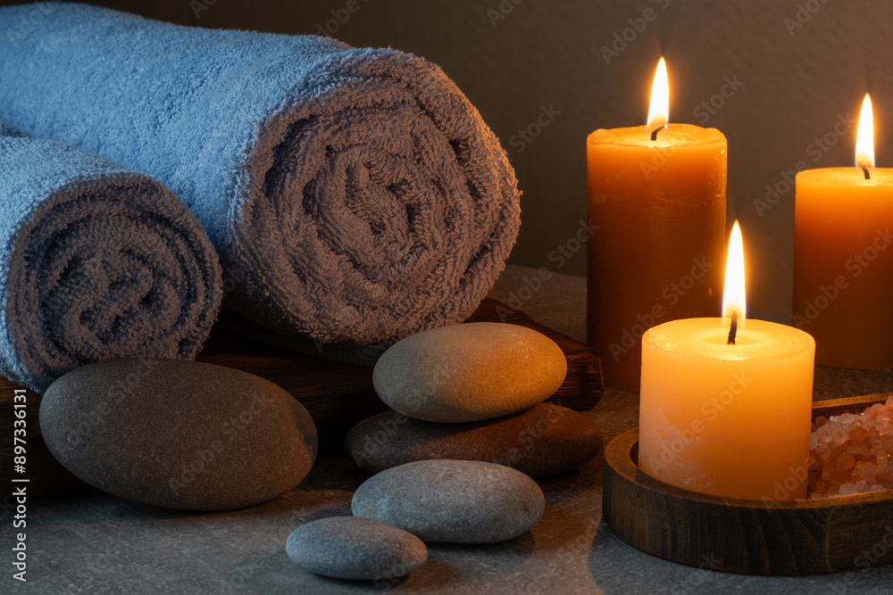 Spa still life with candles, stones and towels on grey background. Spa still life with candles, stones and towels on grey background.