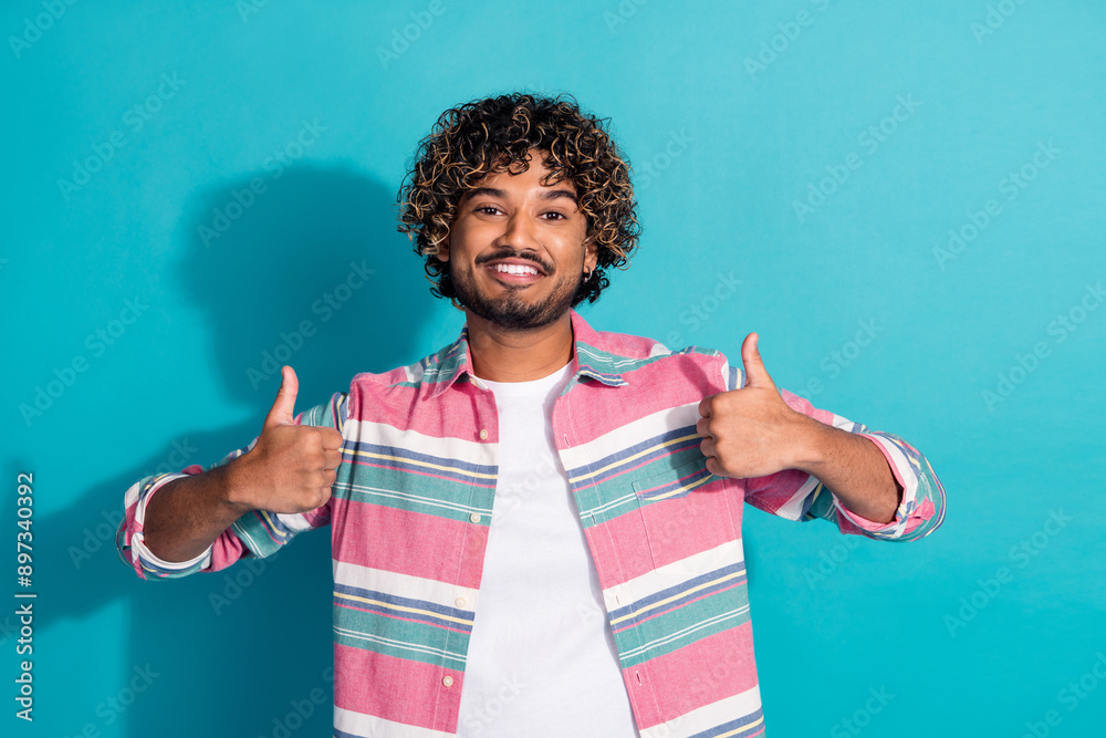 Photo of satisfied glad man wear trendy striped clothes thumbs up isolated on cyan color background