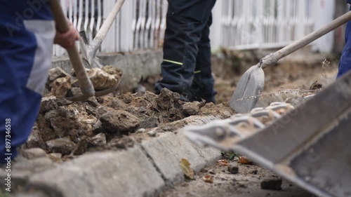 Wallpaper Mural Manual laborers digging gravel with shovels at a construction site. Two workers in blue uniforms manually digging up gravel with shovels at a construction site Torontodigital.ca