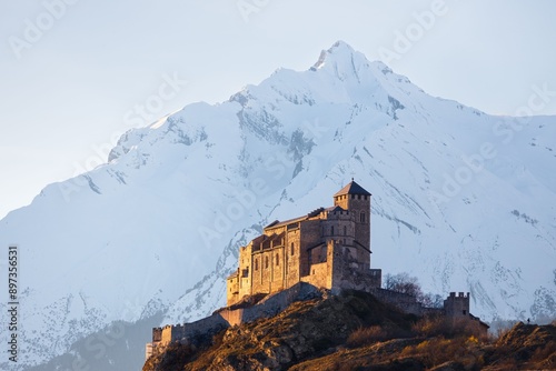 Winter landscape view of the Valere Basilica illuminated before sunset photo