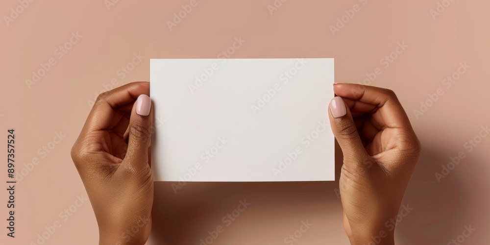 Fototapeta premium blank greeting card mockup with brown complexion manicured hands holding the greeting card horizontally 