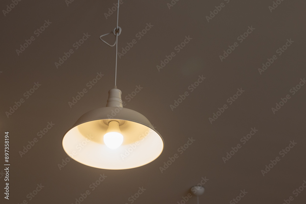 A white light fixture hanging from the ceiling A white light fixture hanging from the ceiling
