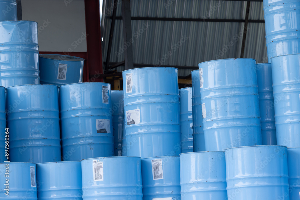 A stack of blue barrels with stickers on them A stack of blue barrels with stickers on them