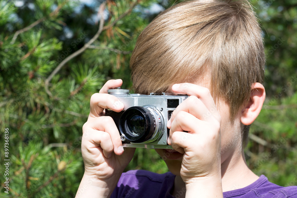 Teenager holds camera and study and take photo. Outdoors. Close up. Teenager holds camera and study and take photo. Outdoors. Close up.