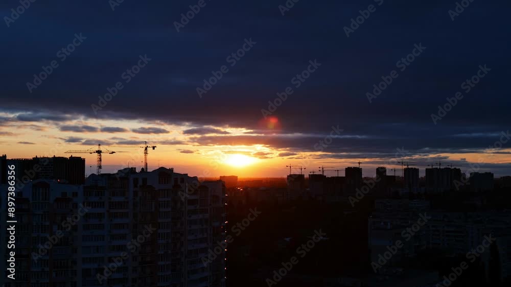 sunset over city, speeded-up sunset over the horizon, the sun sets behind the horizon, the sun's rays break through the clouds, sunset timelapse